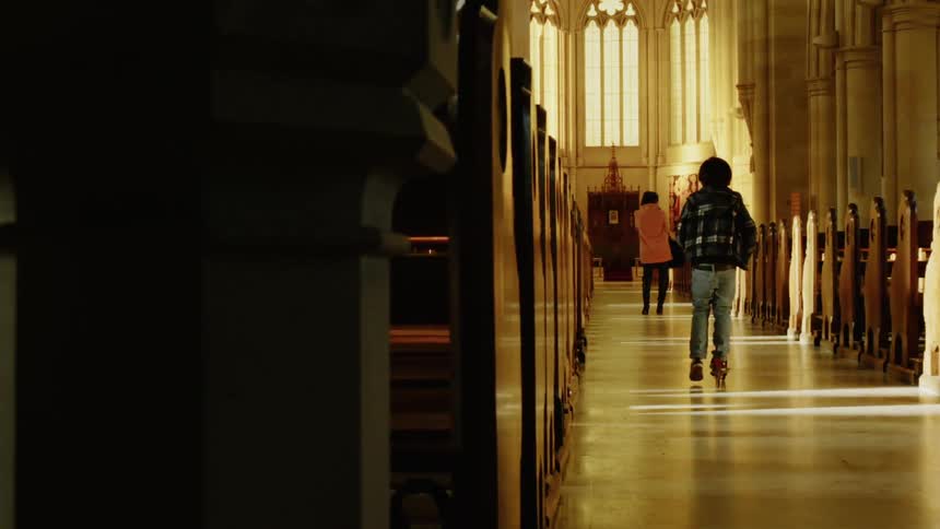 A child travels with a scooter in the church