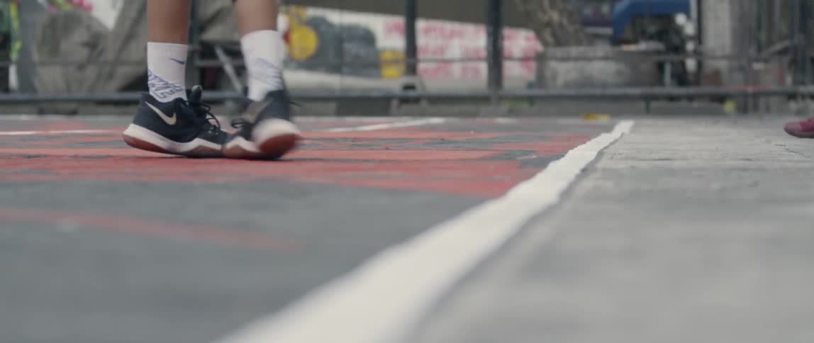 Boys play basketball on an outdoor court