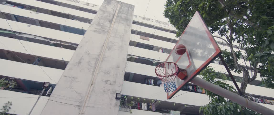 Boys play basketball on an outdoor court