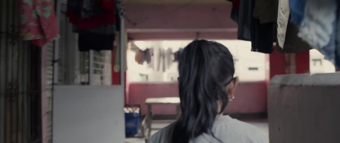 A young girl walks in an apartment complex near hanging laundry