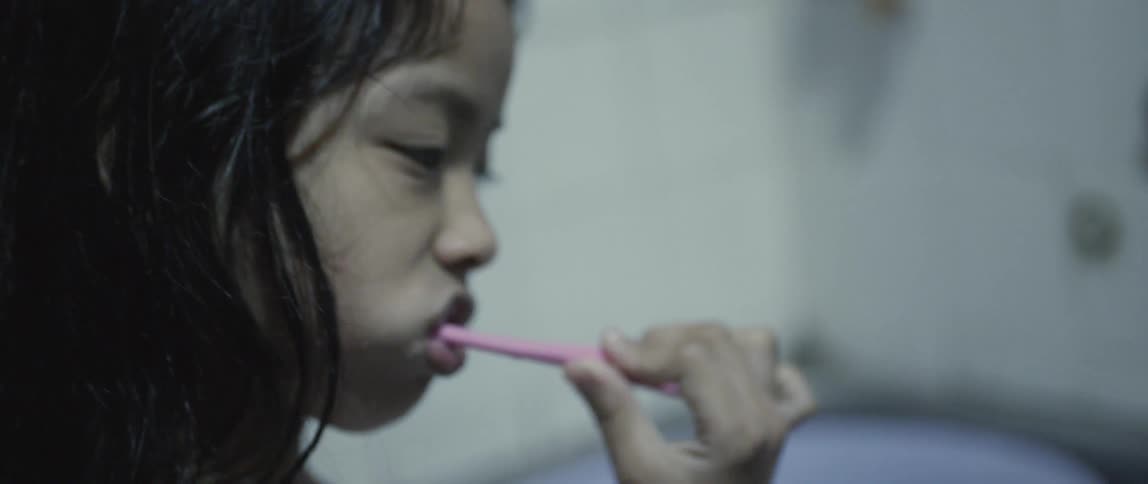 A young girl brushes her teeth