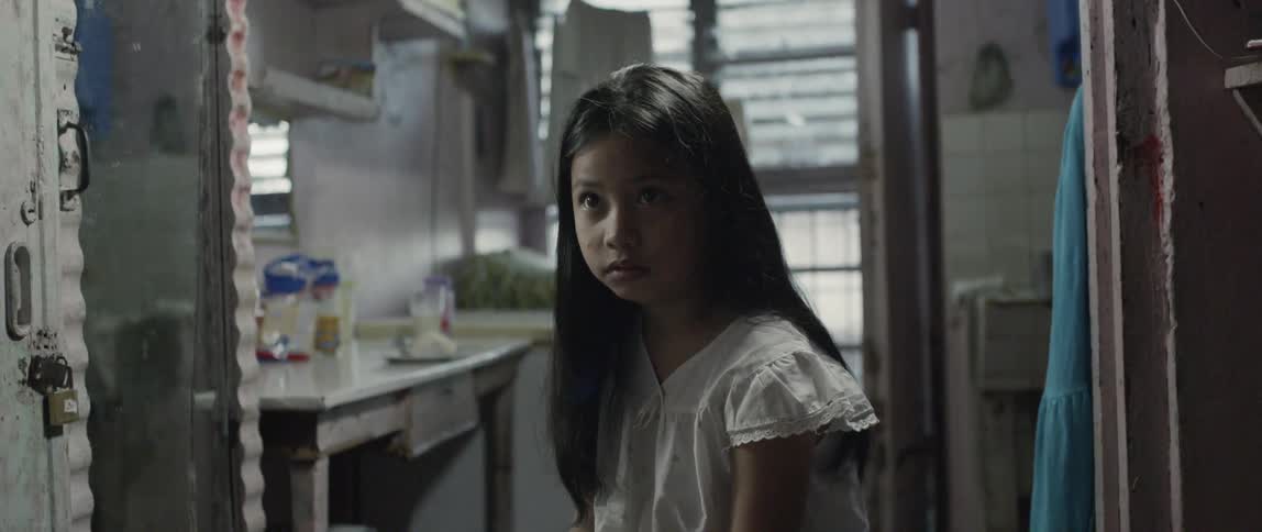 Child stands in a kitchen looking worried