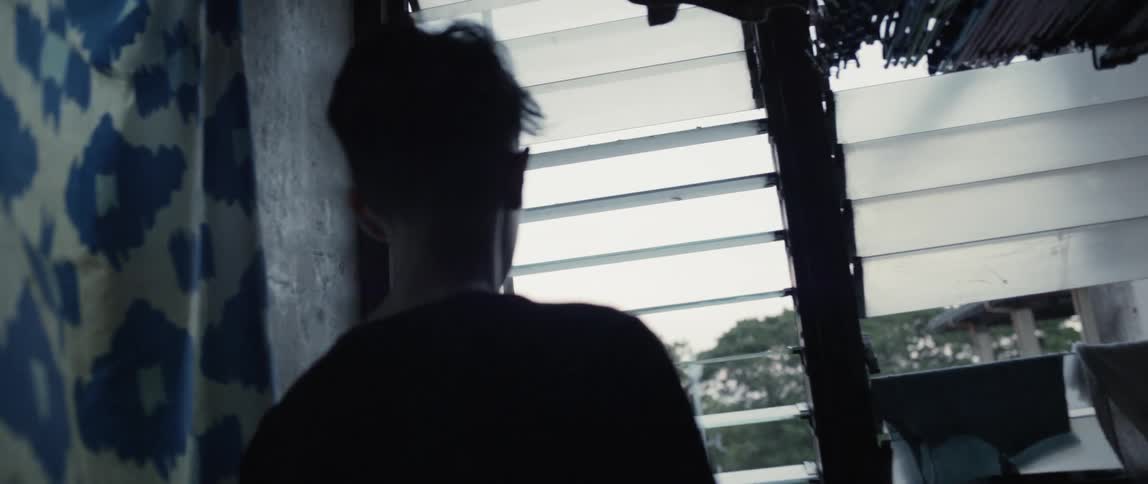 A child walks to the window looking out