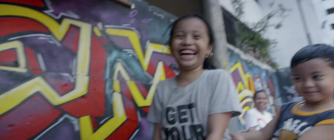 Children laugh and play by the building