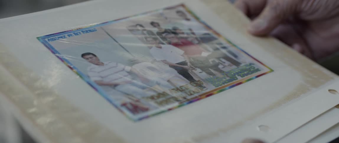 Man holds a photograph sealed with clear plastic
