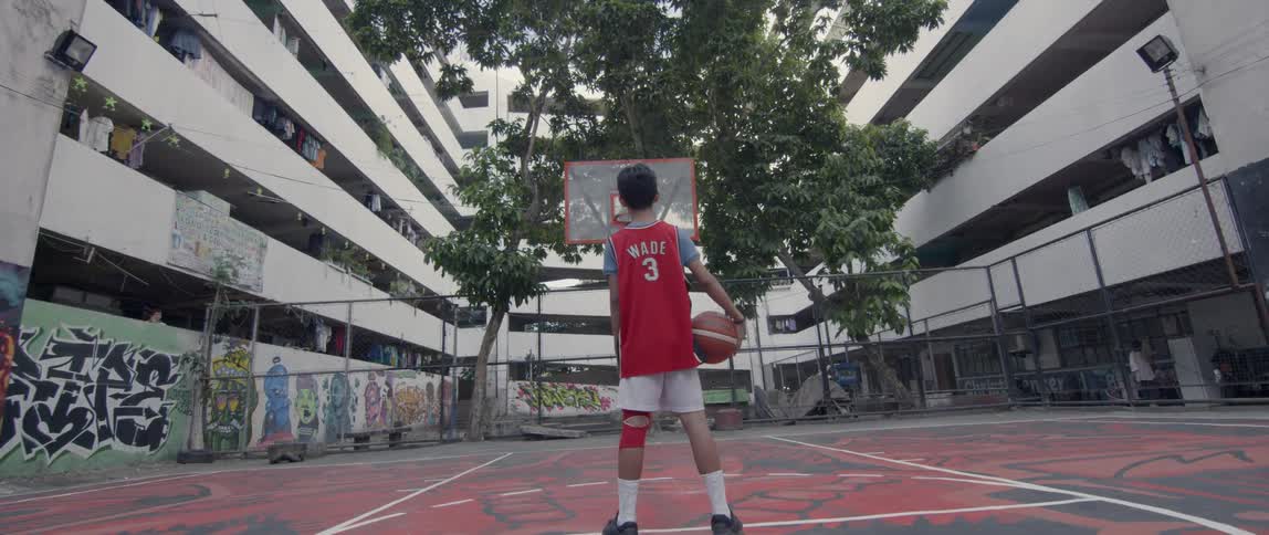 A child wearing a jersey holds a basketball