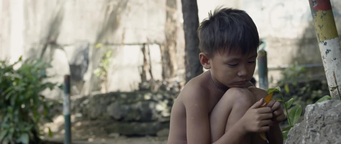 Young boy looks sad while sitting outside