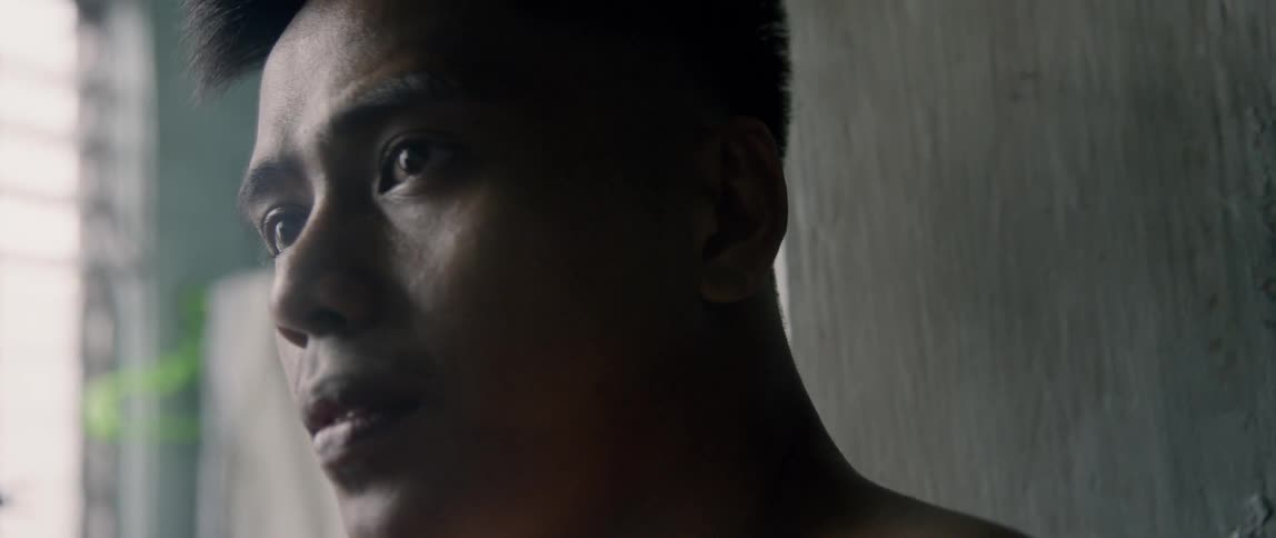 Man stands in a room near a window staring