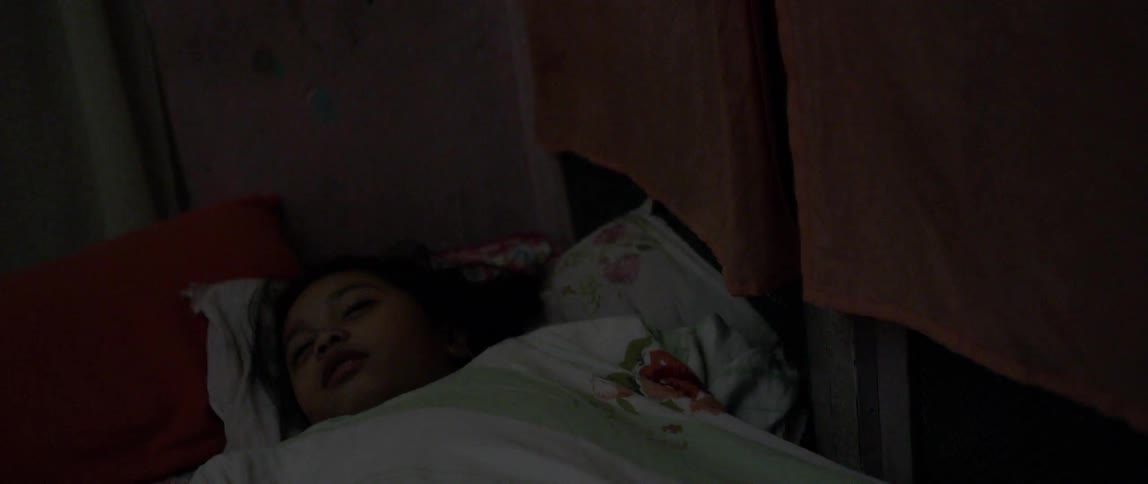 A girl sleeps in a bed