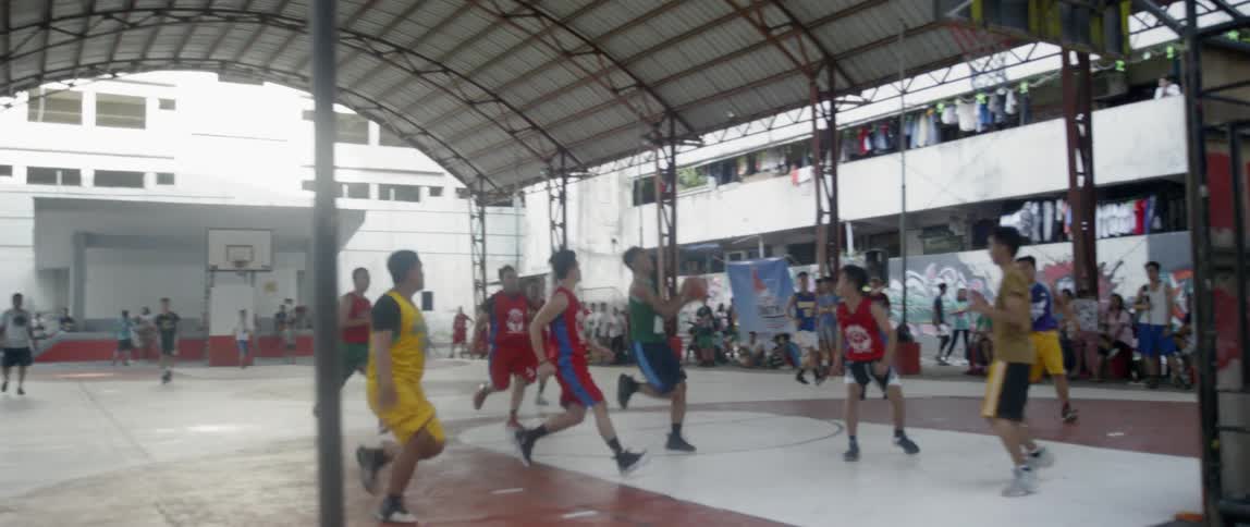 The children race off playing a game of basketball