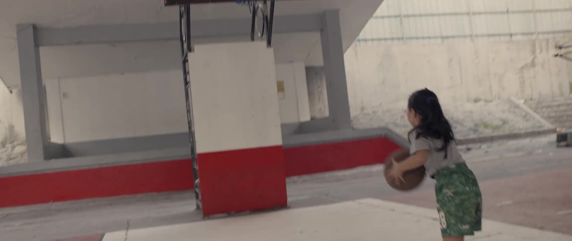 A child dribbles the basketball then shoots