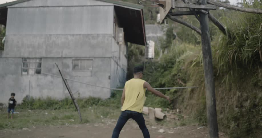 A boy scores a basket and tosses the ball to another