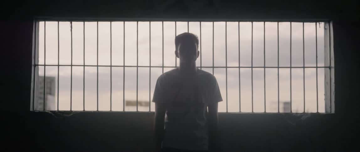 A man stands on the balcony on a cloudy day
