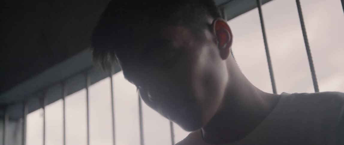 A man rubs his face in the dark room