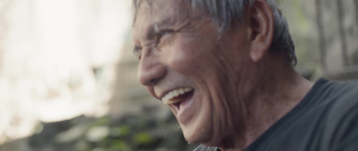 A man laughs on a sunny day