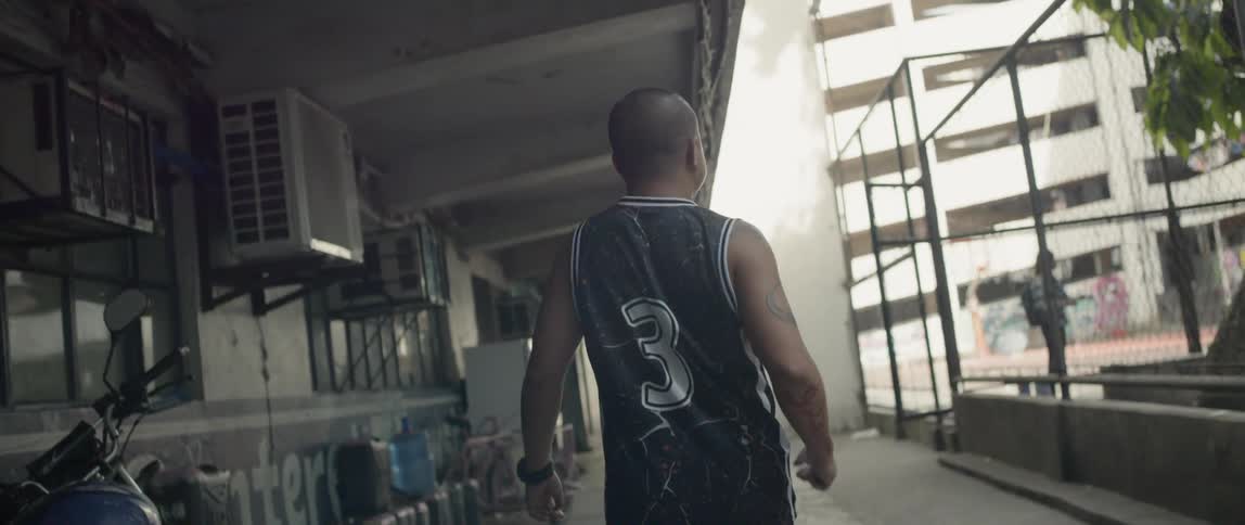 A man slowly walks past the basketball court