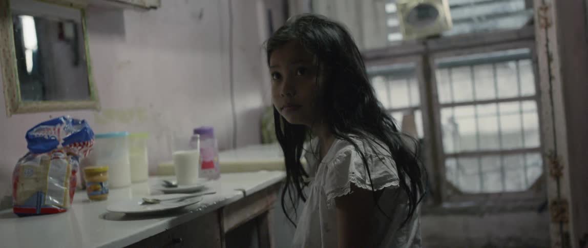 Young girl sits at a kitchen table