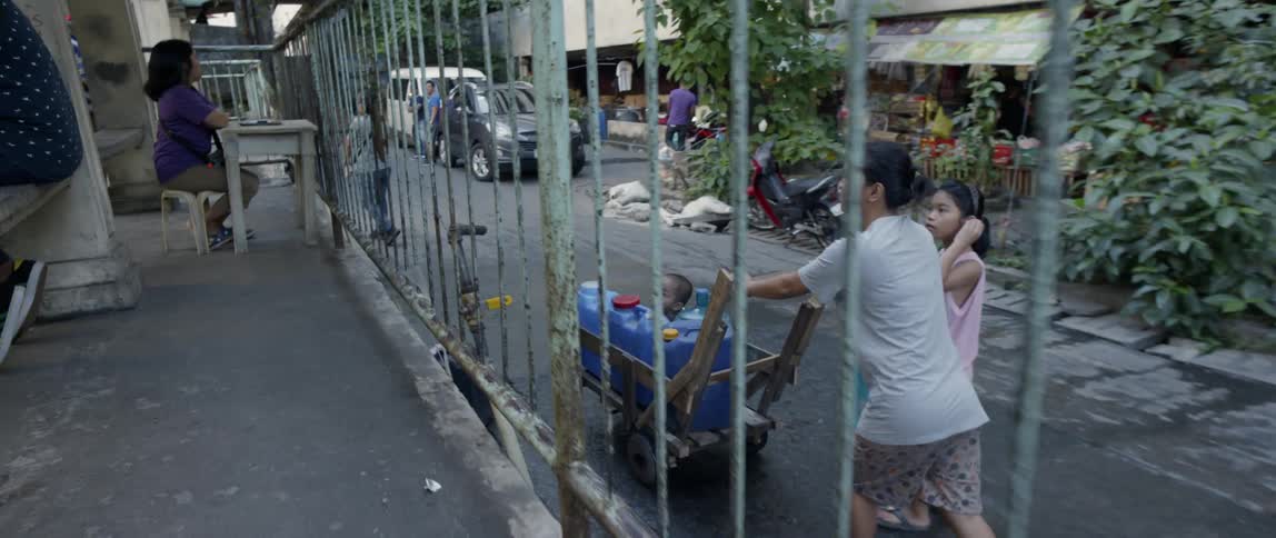 People walk down the alley together pushing a cart