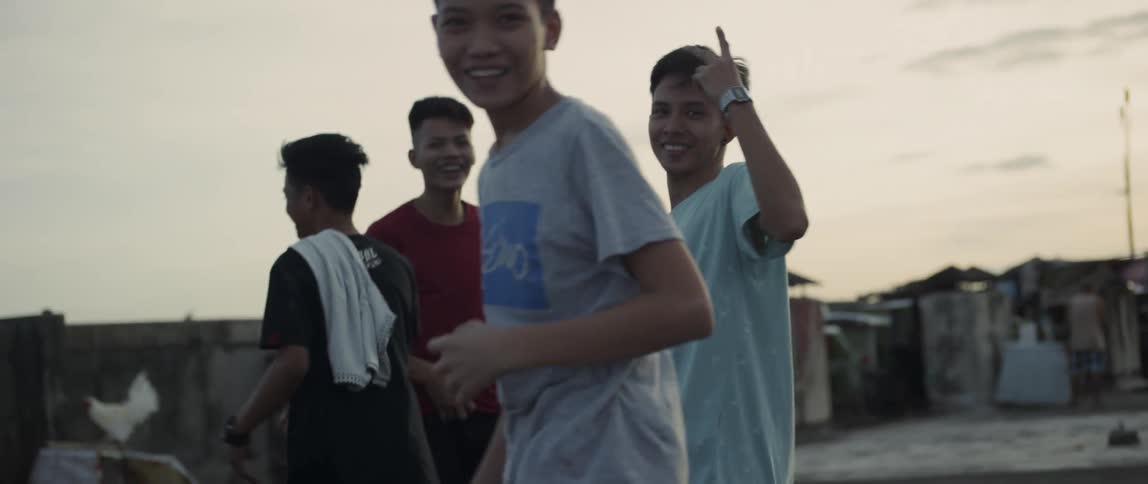 Teenagers smile and walk outside at sunset