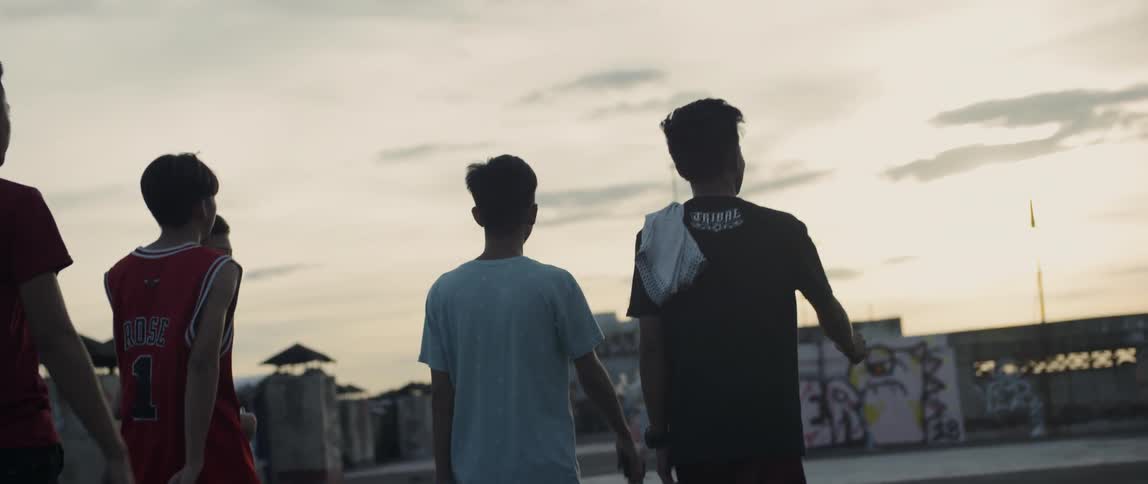 Teenagers walk outside in the city at sunset