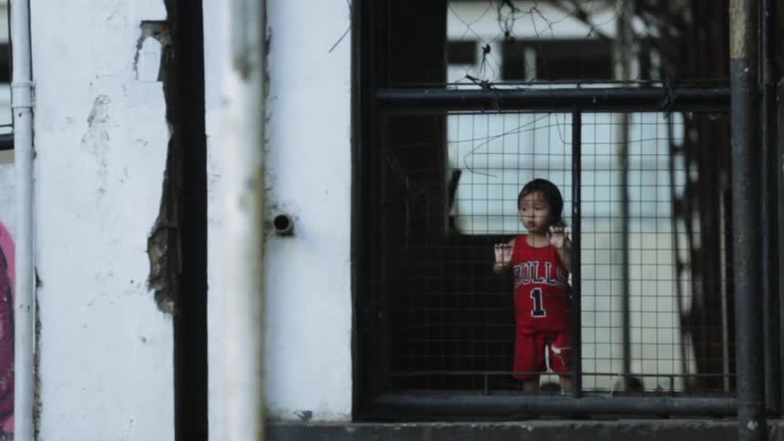 A toddler wears a basketball jersey in an apartment complex