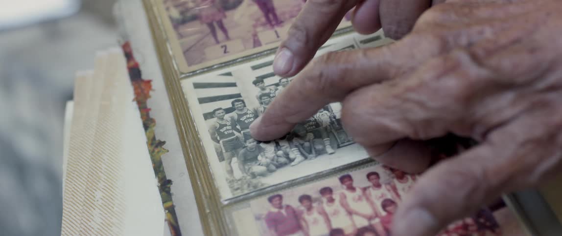 People point to a photograph in a photo album