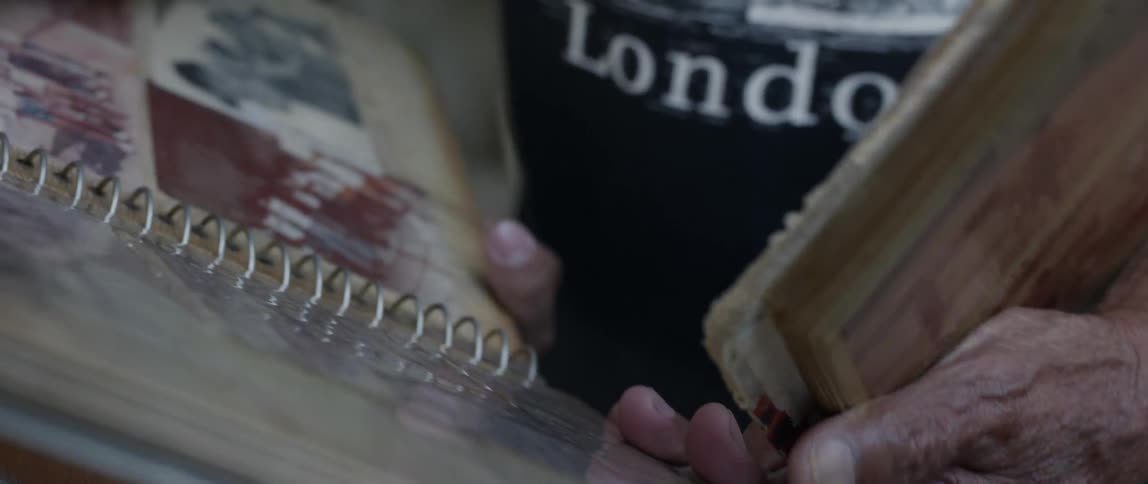 Man points at a photograph in a photo album