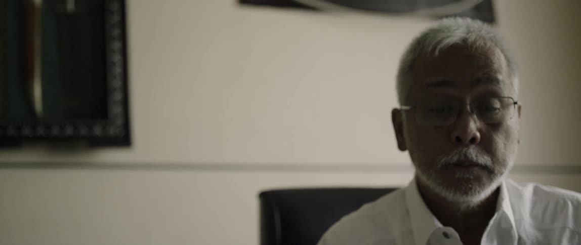 A man wearing glasses looks down
