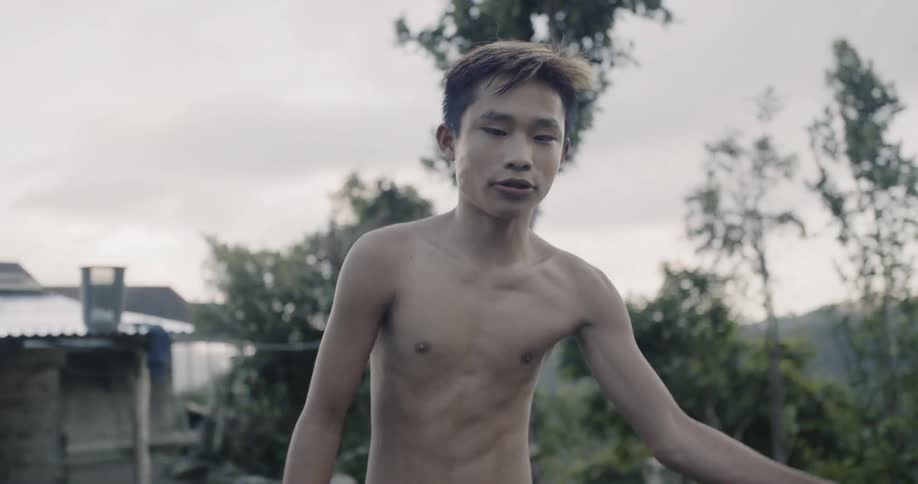 A teenager dribbles the basketball on a windy day