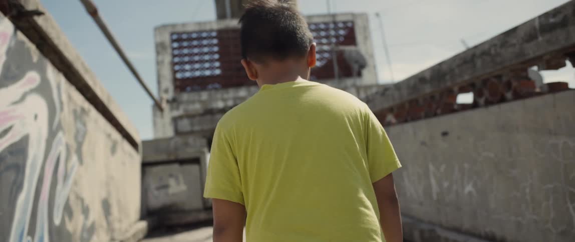 A child walks outside on a sunny day