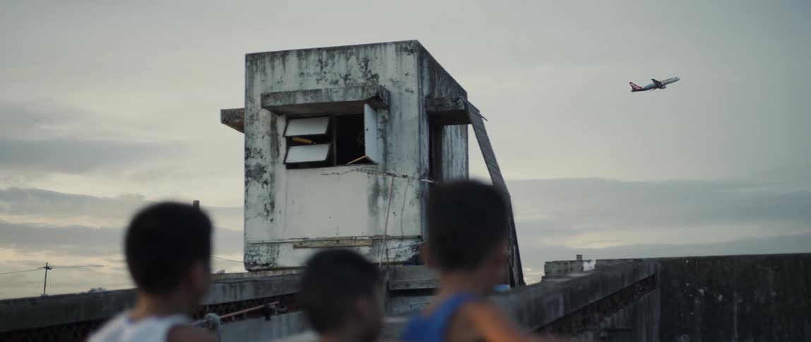 Young boys watch a jet travel across the sky