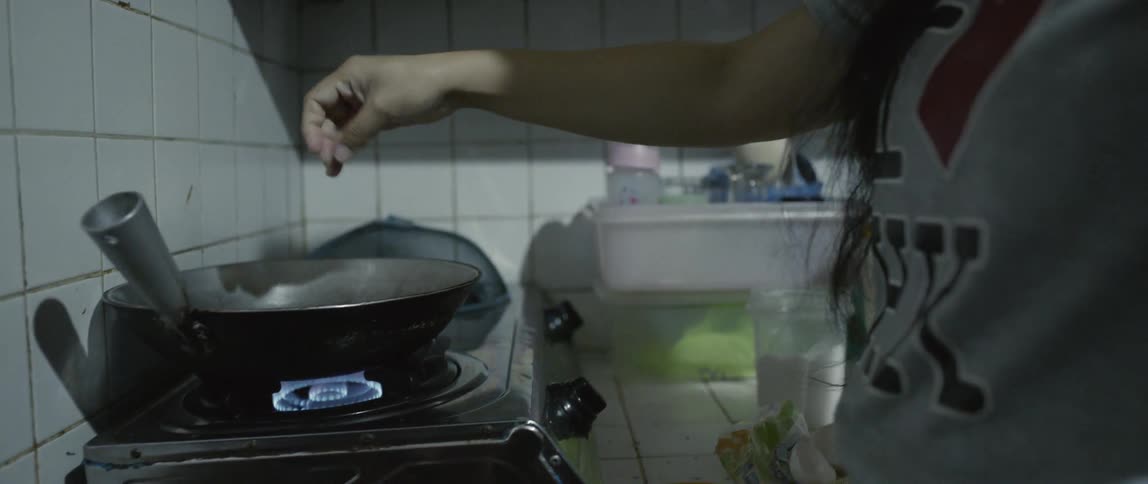 A woman is cooking food in the kitchen