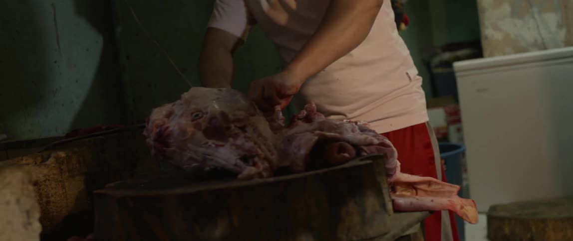 A butcher cuts a chunk of meat