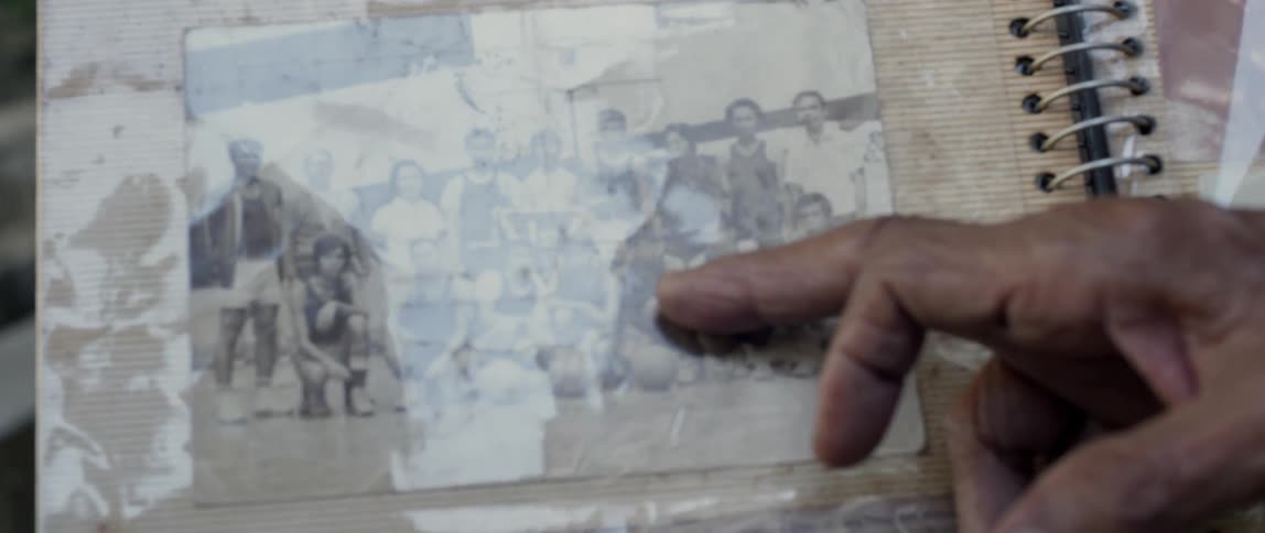 A person points to people in a photograph in an album