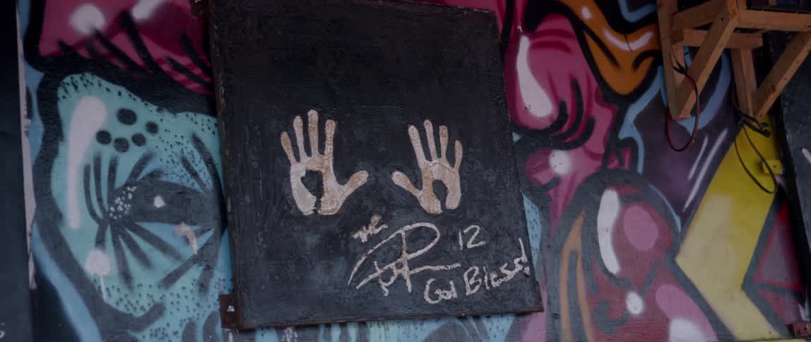 The wall has a painting with two hand prints on it