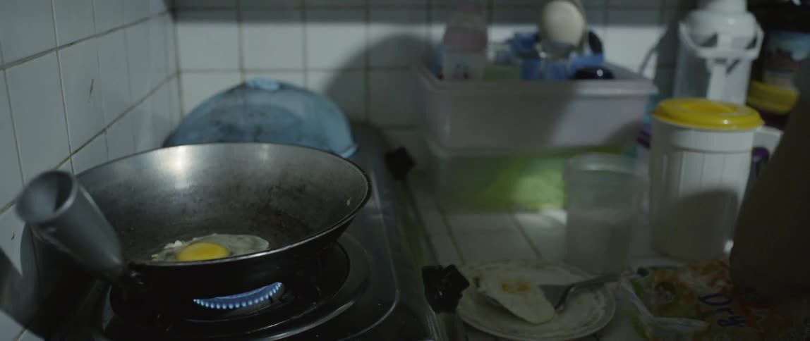 Woman fries an egg at home