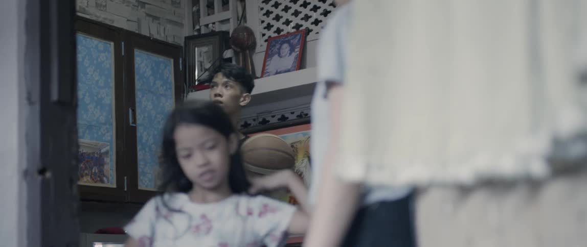 A boy throws his basketball around in the home