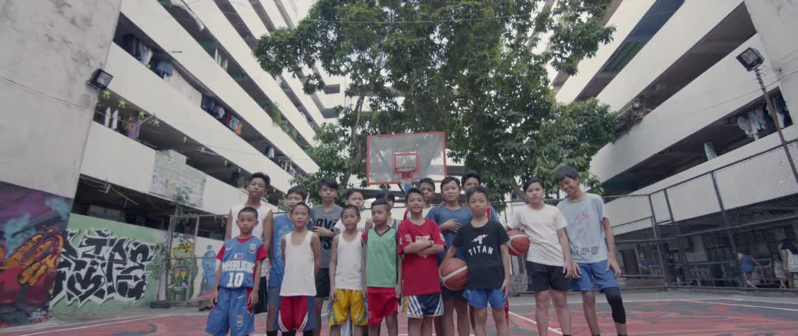 A group of children pose for a photograph on the court