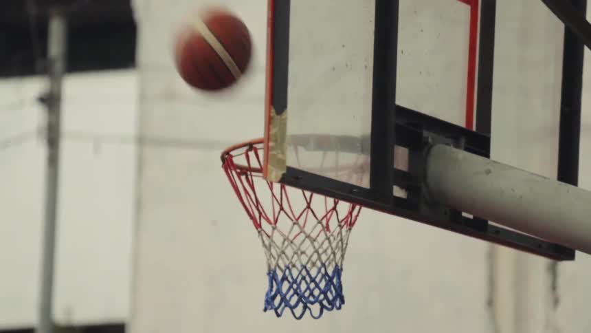 The basketball is thrown and hits the net