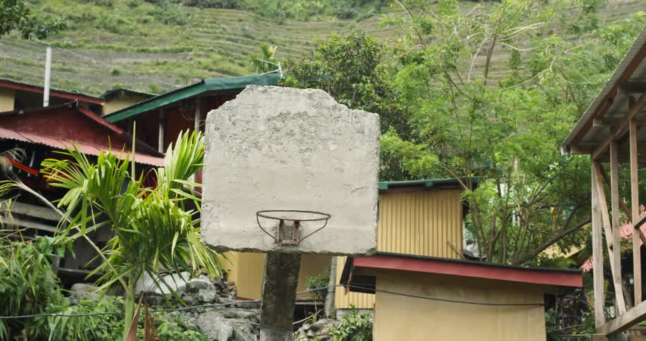 The hoop is near the home by the hill