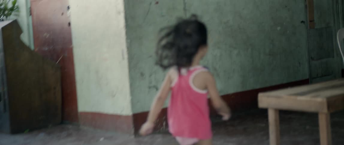 Young girl runs around the corner of a building