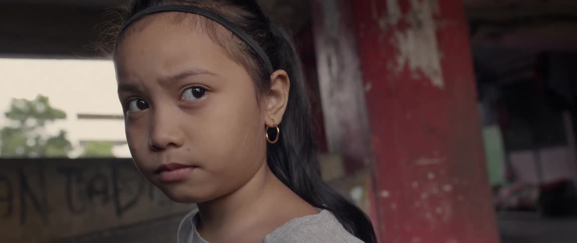 Young girl wearing a hoop earring stares to her left