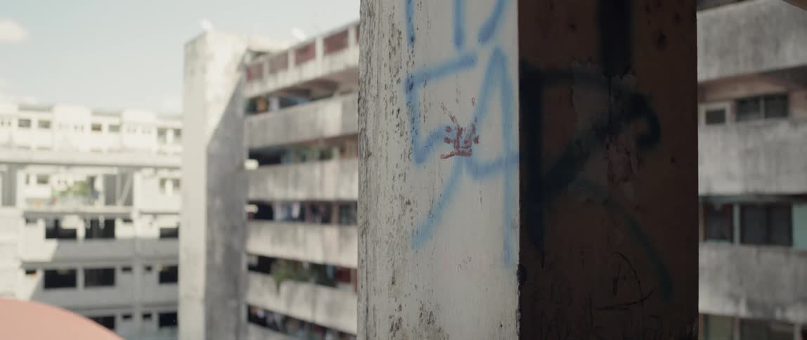 Graffiti covers a concrete post in an apartment complex