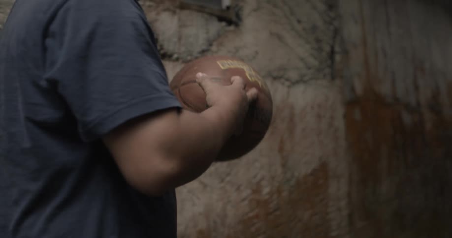 A person carries a basketball down the alley