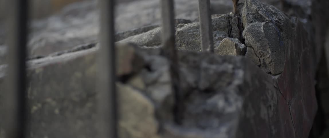 Small metal fence sticks out of a concrete ground