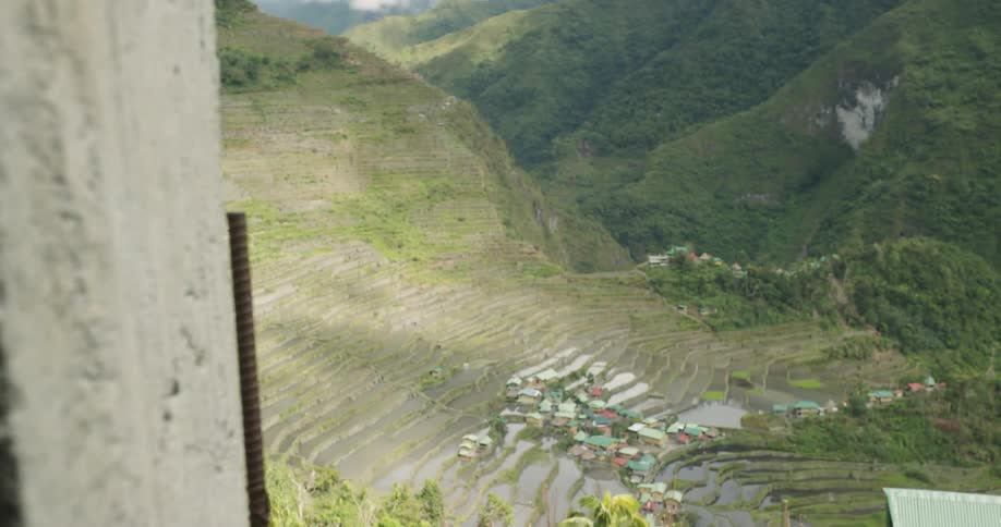 Rice paddies flooded with water are covering a hill in a farming community