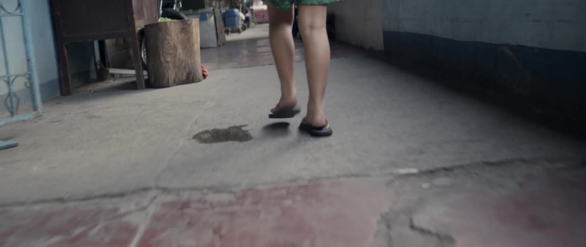 A girl walks down an apartment open-air hallway