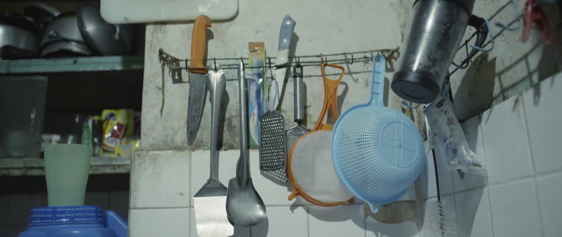 Row of kitchen utensils hanging on a wall