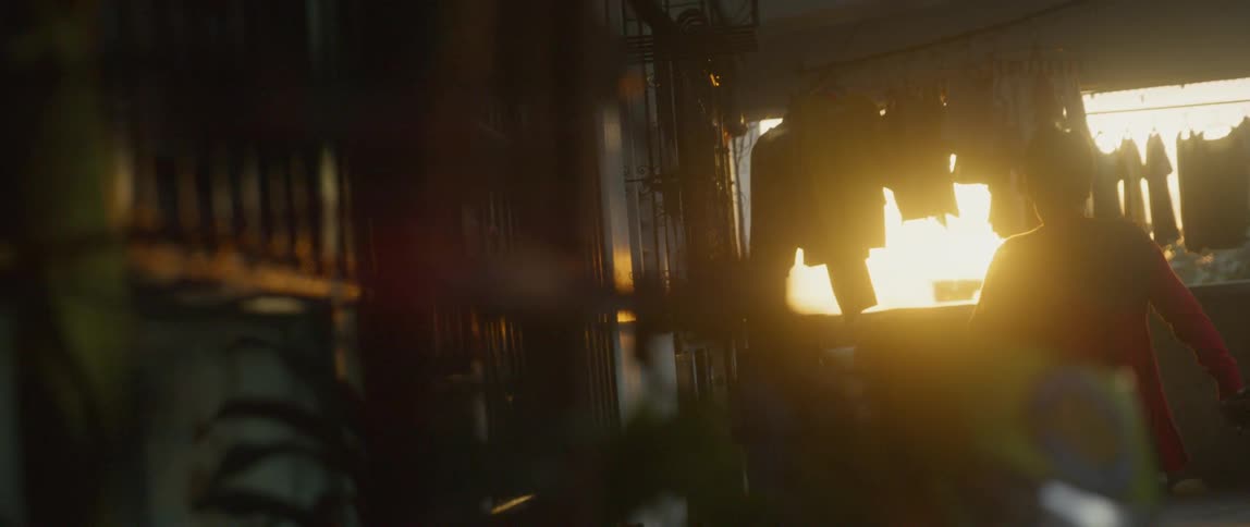 Man walks through a dark building towards the sunlight outside