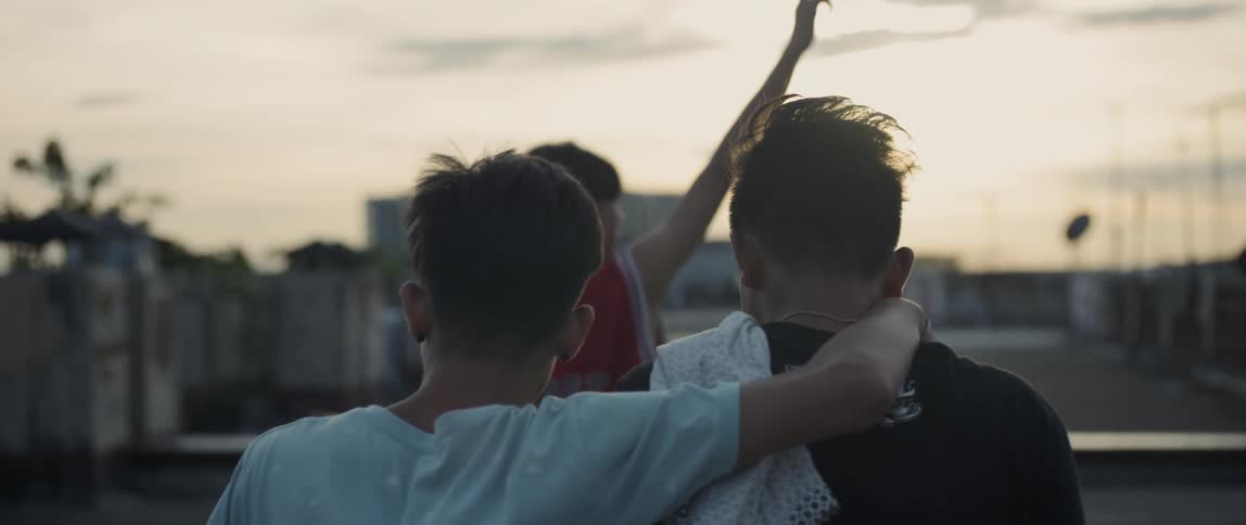 Children walk together arm in arm at sunset